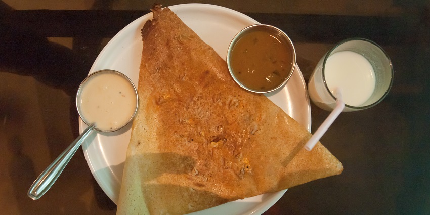A crispy dosa served with coconut chutney and sambar.