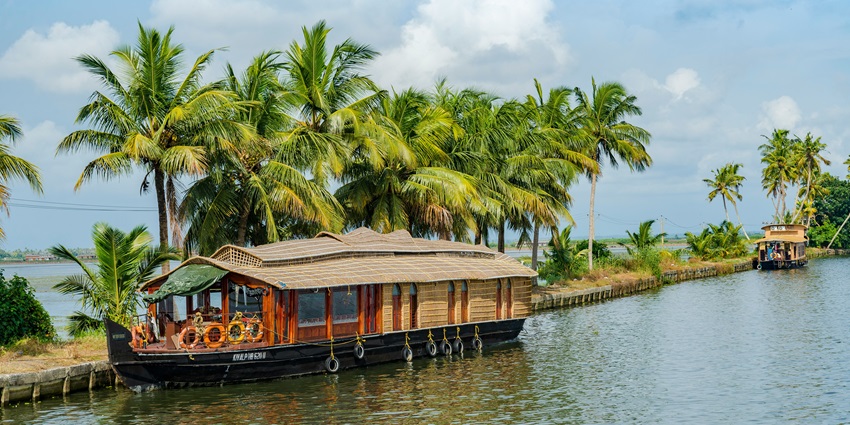 A view of a quaint houseboat on the shimmering blue waters of the Chapora River.