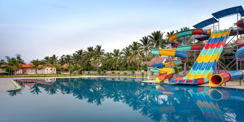 View of the large swimming pool inside the park with colorful slides on the side