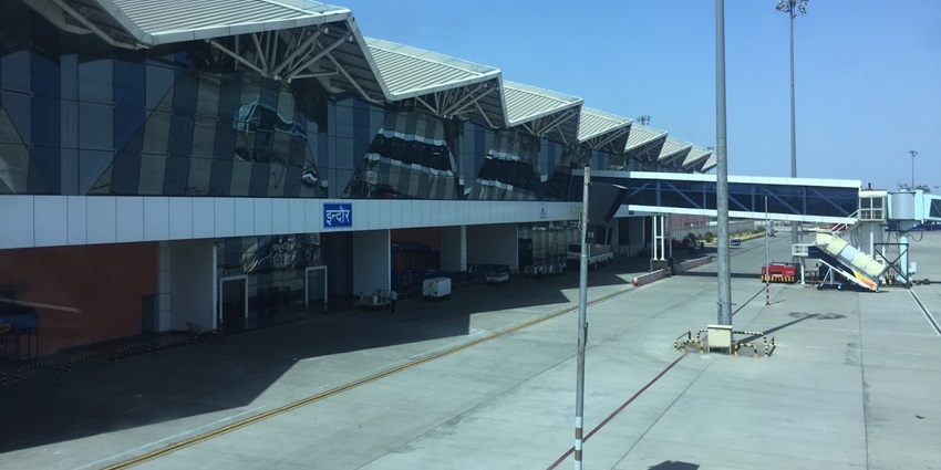An image of the terminal building of Indore Airport in India with a prominent curved roof.