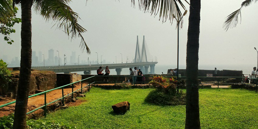 The lush green gardens in front of the Bandra Fort where visitors sit and relax.