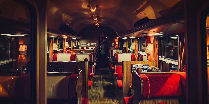 The interior of a first-class train compartment, featuring comfortable seating and decor.