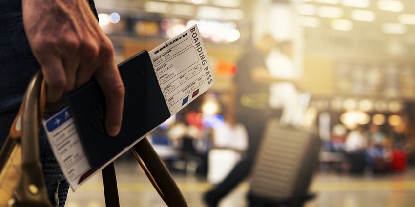 Travel airport boarding pass on a table with a passport and luggage tag