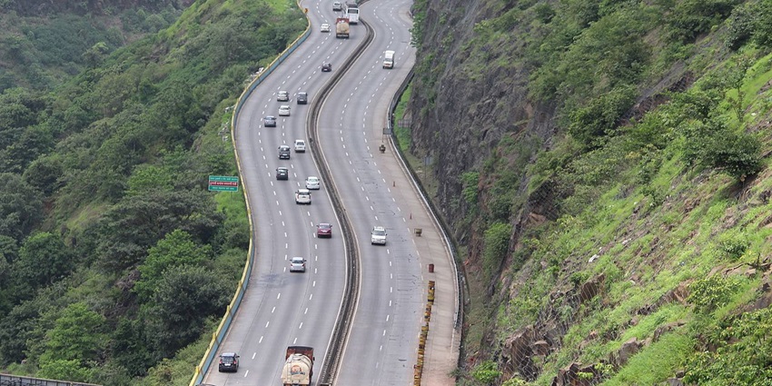 Mumbai to Pune expressway near Lonavala, featuring multiple lanes and surrounding greenery