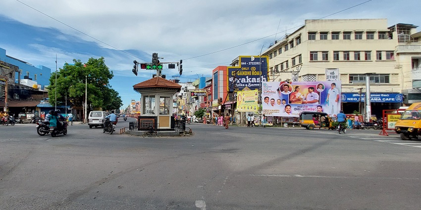 Streets of Kanchipuram with traffic lights in the middle and shops with big posters