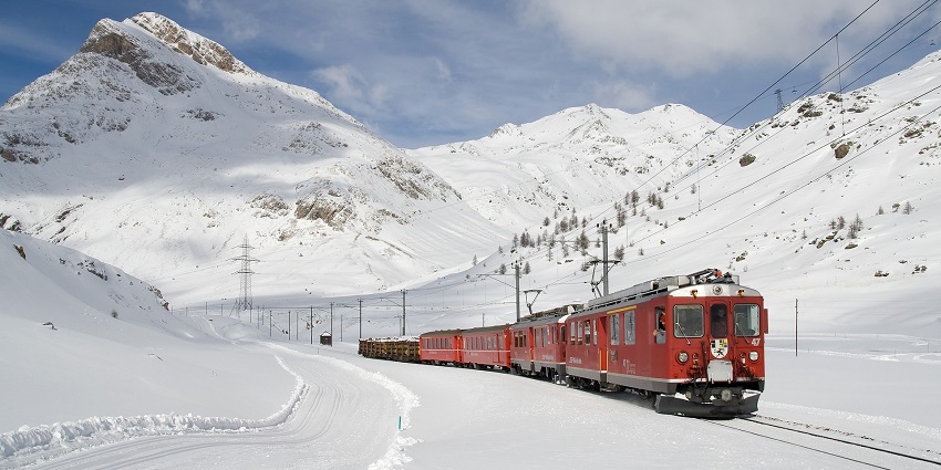 Train passing through a snowy landscape, showcasing winter travel and scenic views.