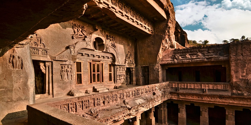 Ekvira Temple, a gray concrete structure, stands under a cloudy sky.