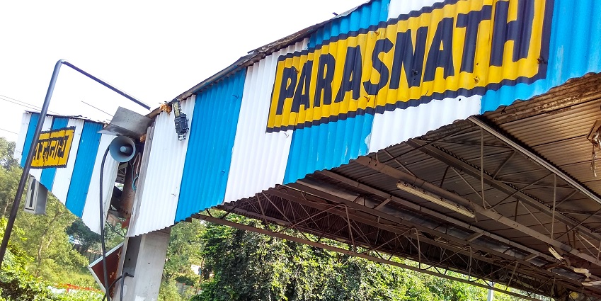 Platform area of Parasnath Railway Station showcasing a lady and a coolie with baggage
