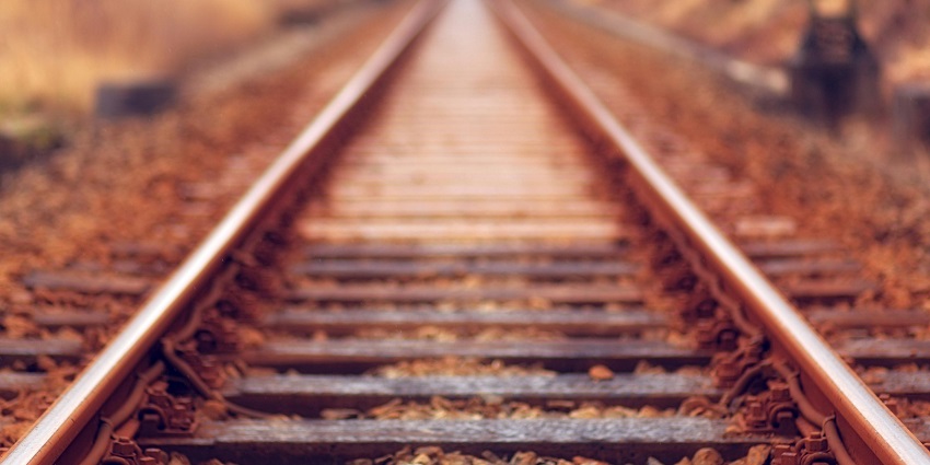 A marvellous view of a railway track with small and big rocks around it during the day.