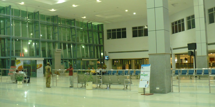 View of Nagpur Airport terminal building with parked vehicles and clear skies in the background