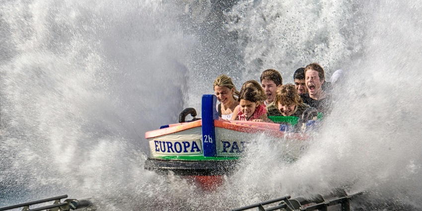 Excited children gliding down colourful water slides, bursting with giggles and joy.