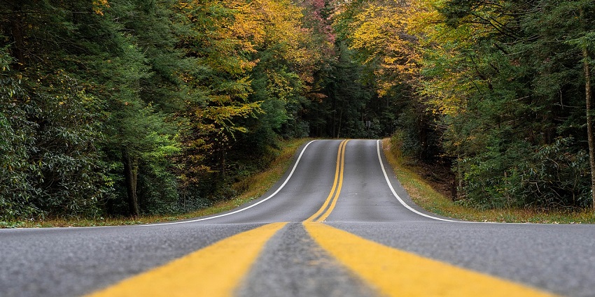 National Highway in Rajasthan with smooth paved roads and visible hills at a distance.