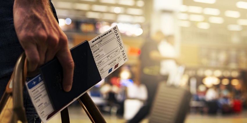 A close-up of a traveller's boarding pass at the airport, ready for departure.