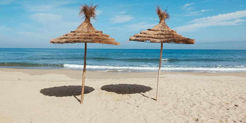 View of two sheds on the golden shores and the picturesque beach far ahead