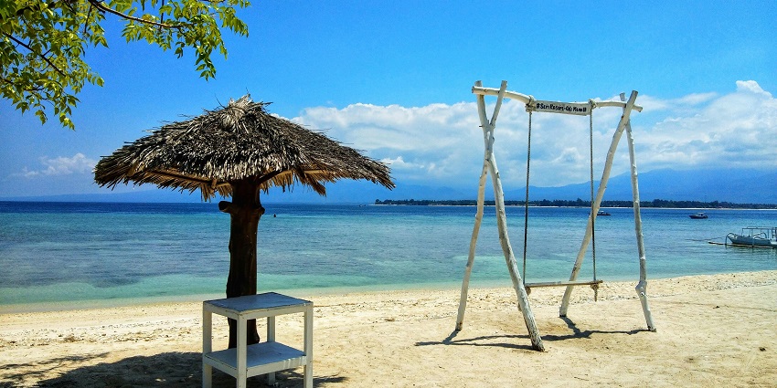View of a swing and a small shores on the golden shores with waves crashing