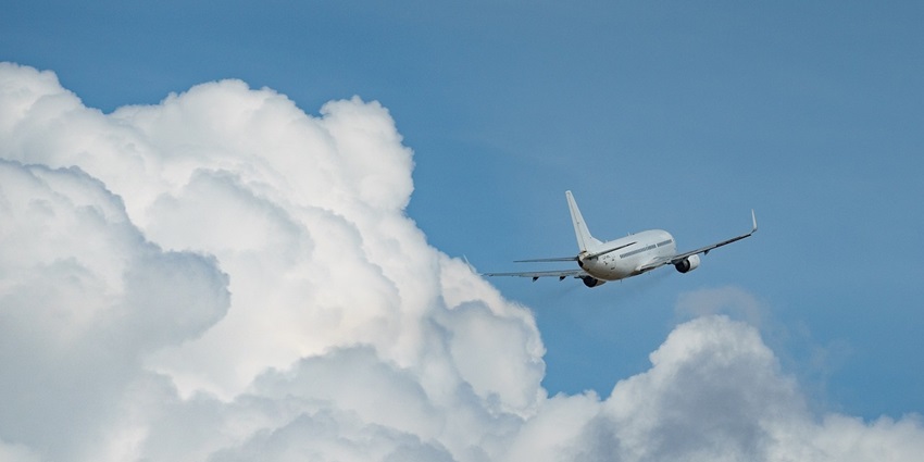 Airplane at the airport, ready for takeoff against a clear blue sky backdrop.