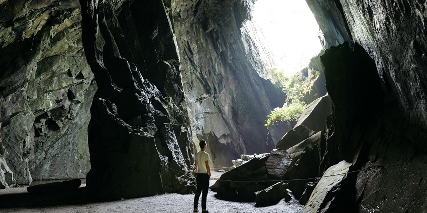 View of a man standing inside the majestic halls of the Kukkal caves