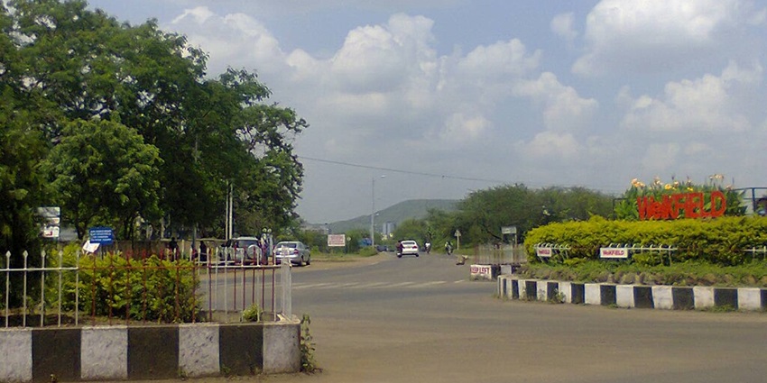 A busy road with greenery near the Pune International Airport.