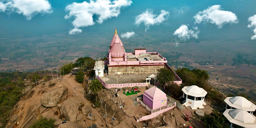 Aerial view of the Mumabdevi temple with the blue sky and the sky surrounded by majestic hills