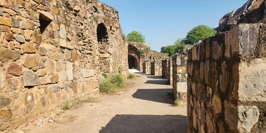 View of the halls of the fort with rugged walls on both sides against the clear blue sky