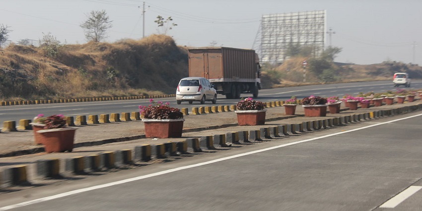 A picture of a highway leading to Sangli, with multiple vehicles moving.