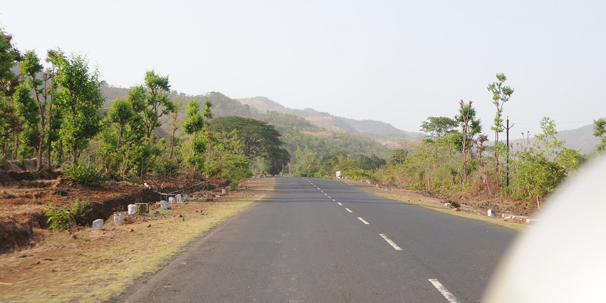 A rural highway in Maharashtra, India, with two lanes stretching into the distance.