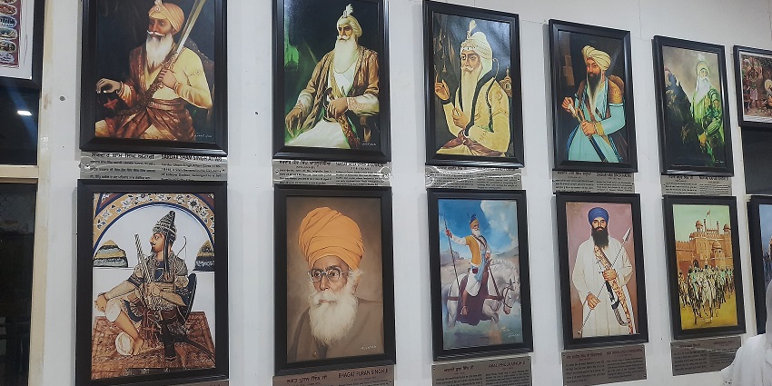 A picture of a museum with the paintings of Sikh Gurus placed on display