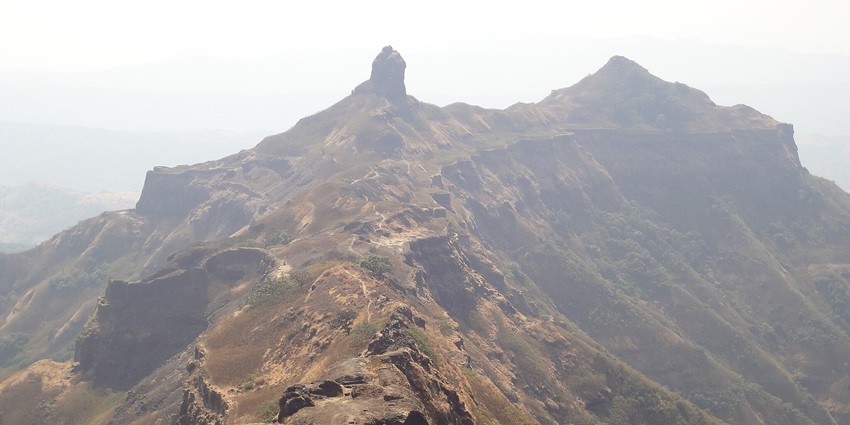 A view of the historic Torna Fort in Maharashtra, India, surrounded by lush green hills.