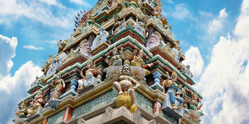 An image of Hindu figurines in one of the important temples in Madurai adorned with vibrant flowers.
