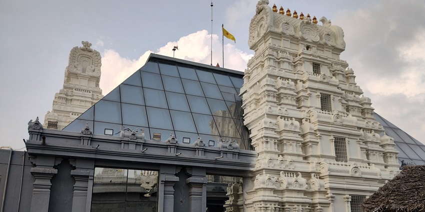 A temple combining traditional Dravidian architecture with modern glass pyramid elements.
