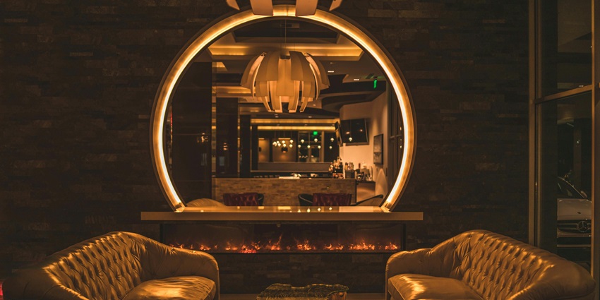 Image of two white decorated sofa places around the seating area with vibrant and dim lights around