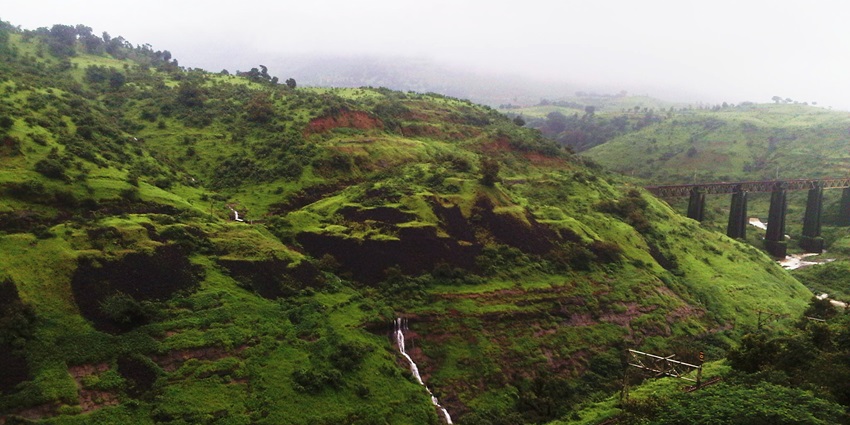A scenic view of the rolling hills of Igatpuri with a cover of lush greenery and a hover of clouds