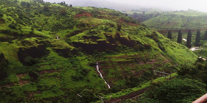 A panoramic view of the verdant hills of Igatpuri under a cover of misty air, creating a foggy ambience