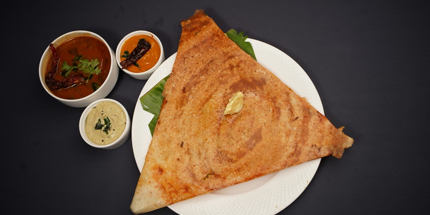 A delicious triangular dosa served on a plate, ready to delight your taste buds!