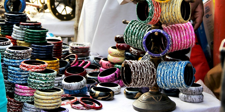A view of colourful bangles at display in a street market during the daytime.