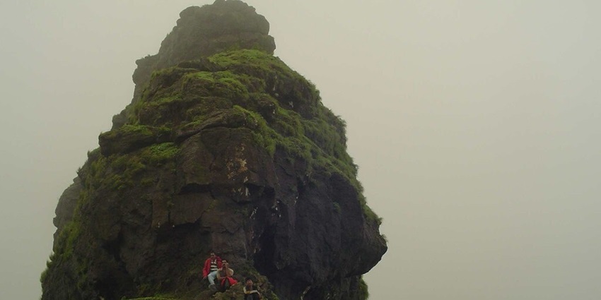 Irshal Gad Fort pinnacle offers stunning views, showcasing rugged terrain and greenery.
