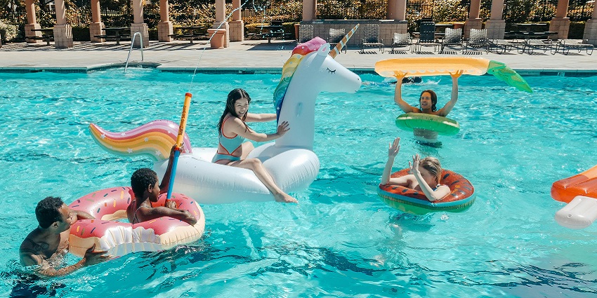 A shot of kids using floating tubes in the pool.