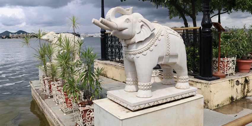 Jag Mandir Palace on Lake Pichola of Udaipur with marble domes surrounded by water.
