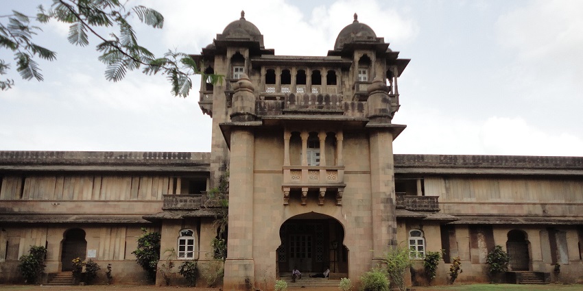 A view of the Jaivilas Palace in Jawhar featuring white facade and rustic architecture.