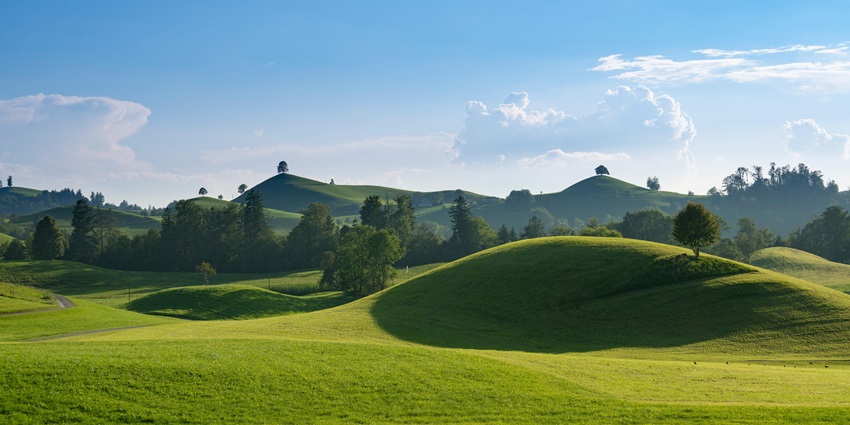 Lush green hills meet clear blue skies in a stunning view reminiscent of Jawhar.