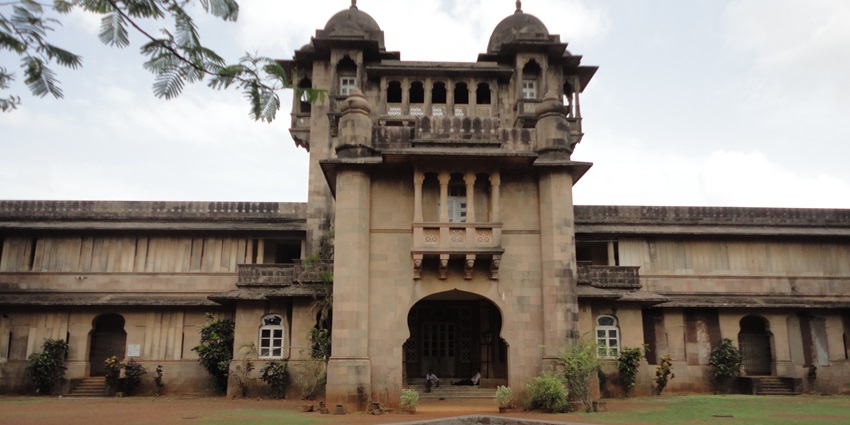 An image of the majestic view of Jawhar Rajwada surrounded by lush greenery and heritage charm.