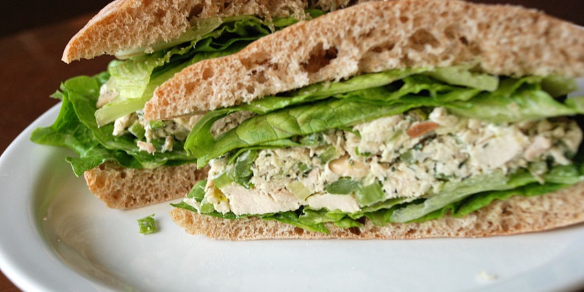 A sandwich is presented cut into halves with toothpicks inserted to keep them bonded, one of the best food in Bandra.