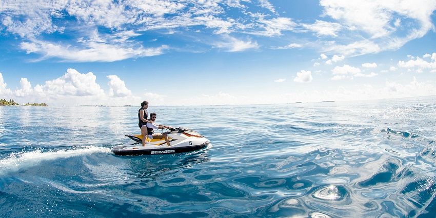 A picture of jet skiers touring through waves on Chivla Beach captures the fun of water sports.