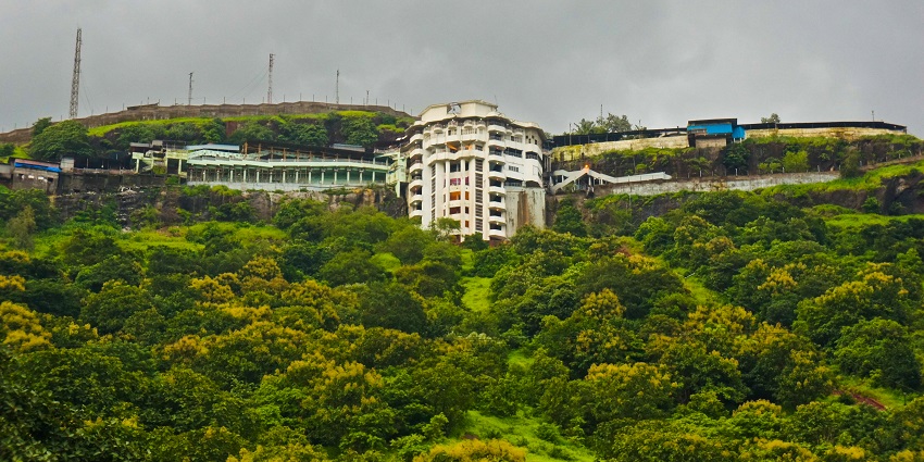A distant picture of the Jivdani Temple taken from far away, showcasing the lush and verdant greenery it is surrounded by