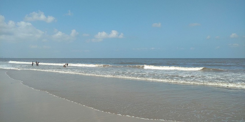 A serene Juhu Beach morning with gentle waves and soft sunlight which makes it one of the most sought places to visit in mumbai central
