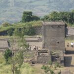 Picturesque view of an ancient fort surrounded by lush greenery and hills