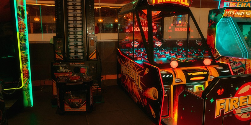 View of arcade game machines in Just Kidding—Play and Party, combining play areas and celebration spaces