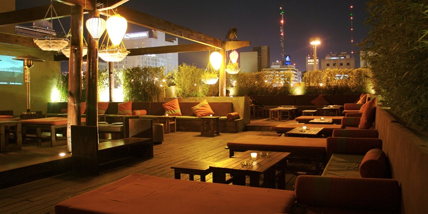 Image of a rooftop restaurant decorated with beautiful fairy lights under beautiful night sky