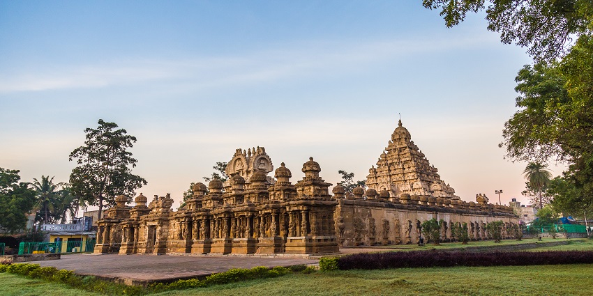 Kailasanathar Temple illuminated at dusk with intricate carvings and green lawn