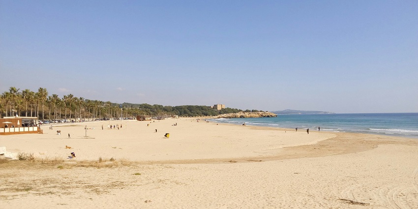 A serene view of Kalamb Beach featuring golden sands and shimmering blue waters.